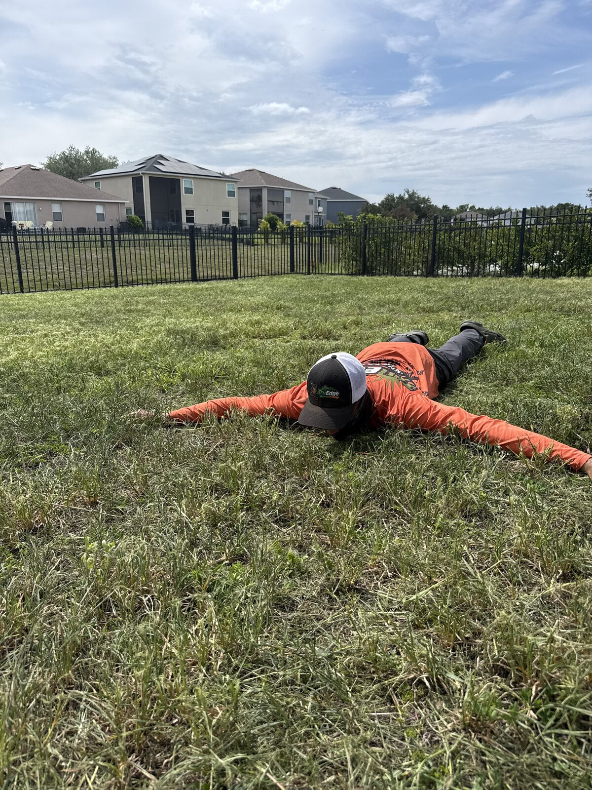 TruEdge crew member spread out on freshly cut lawn after service