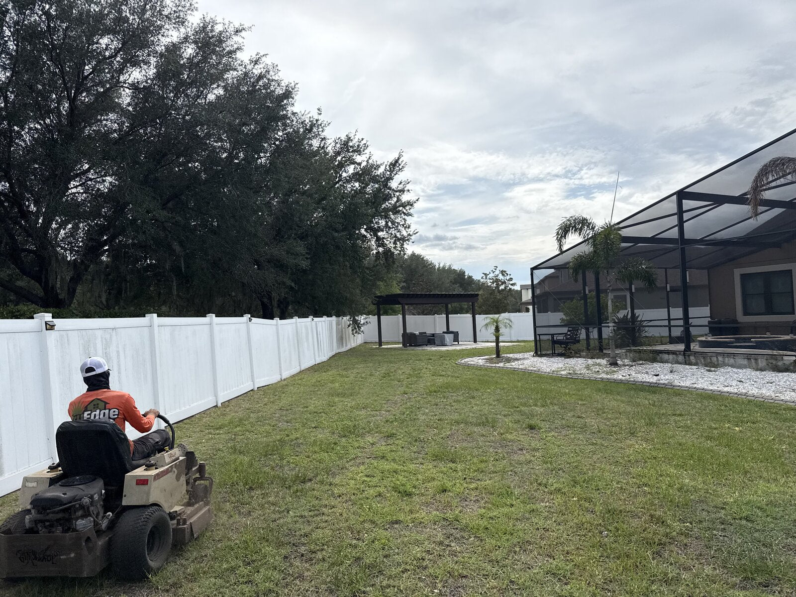TruEdge crew member mowing a backyard with a zero-turn mower